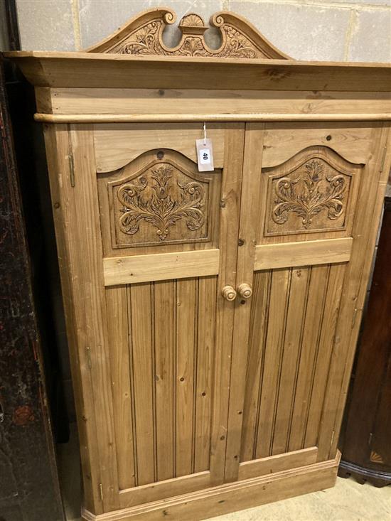 A Victorian style carved pine two door dwarf cabinet, width 98cm, depth 56cm, height 150cm